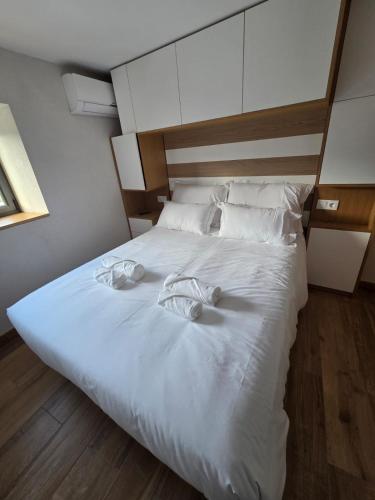 a large white bed with two towels on it at Quinta da Estacao in Marco de Canaveses
