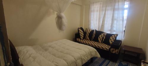 una camera da letto con un letto e una finestra di Airbnb in Mwea town Kabulstan apartment a Thiba