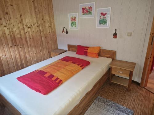 a bedroom with a large bed with orange and red blankets at Halmis FeWo in Derenburg
