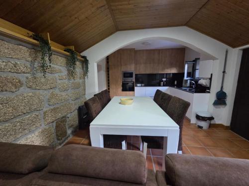 a kitchen with a white table and some chairs at Quinta da Estacao in Marco de Canaveses