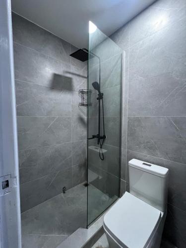 a bathroom with a toilet and a glass shower at Sylz Residence Studio in Accra