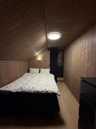 a bedroom with a bed in a room with wooden walls at Exclusive Cabin with Sauna in Fossmo