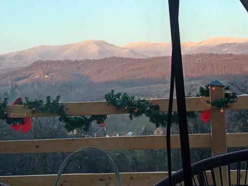 a view of the mountains from a deck with christmas decorations at MajdanskiKutak2 in Gornji Milanovac
