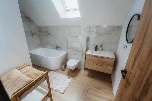 a bathroom with a tub and a toilet and a sink at Prázdninový dům Sobotín in Sobotín