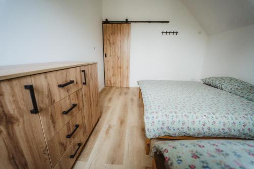 a bedroom with a bed and a wooden dresser at Prázdninový dům Sobotín in Sobotín