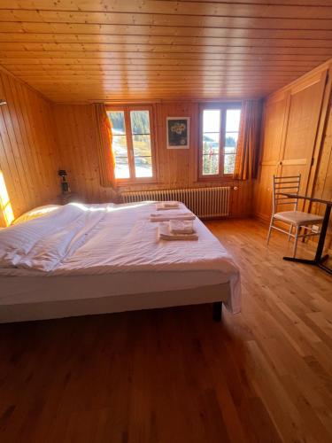 a bedroom with a large bed in a wooden room at L'Auberge de la Combal in La Comballaz