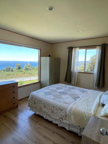 a bedroom with a bed and a large window at Casa con acceso directo al lago y hermosas vistas in Puerto Varas