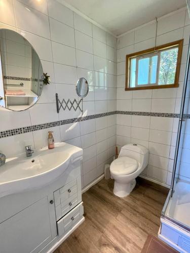 a white bathroom with a sink and a toilet at Casa con acceso directo al lago y hermosas vistas in Puerto Varas