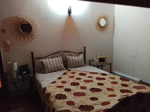 a bedroom with a bed with a floral comforter at Casa Atelier Designer Moda Sandra Silva in Alpalhão