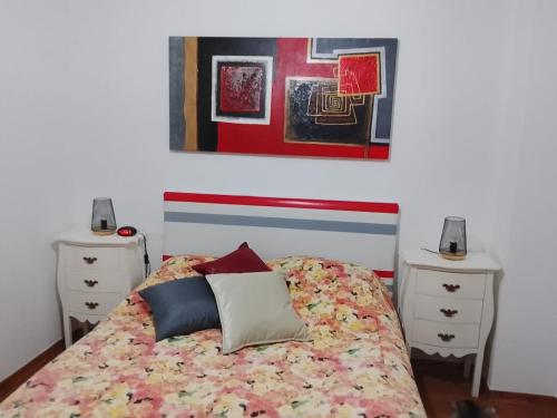 a bedroom with a bed with pillows and two night stands at Casa Atelier Designer Moda Sandra Silva in Alpalhão