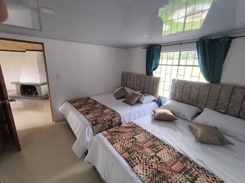 a bedroom with two beds and a window at Cabaña El Laurel in Pasto