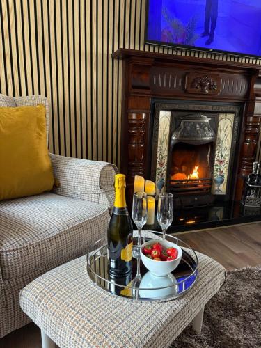 a living room with a table with a bottle of wine and glasses at Katies Cottage in Gortaclare