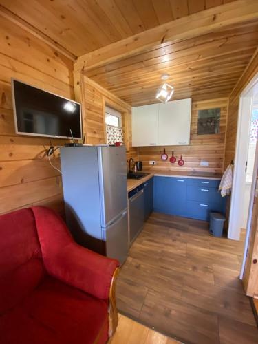 een keuken met een koelkast en een rode bank bij Kajakiem z Marzysza in Marzysz