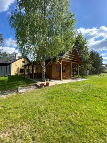 een huis met een boom in de tuin bij Kajakiem z Marzysza in Marzysz