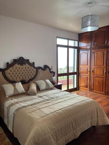a bedroom with a large bed with a large window at Casa estrelicia II in Relógio do Poiso