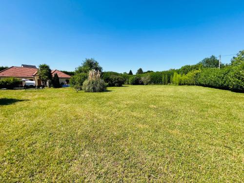 een groot grasveld met een huis en bomen bij Maison spacieuse avec grand jardin Cosne-sur-Loire in Saint-Père
