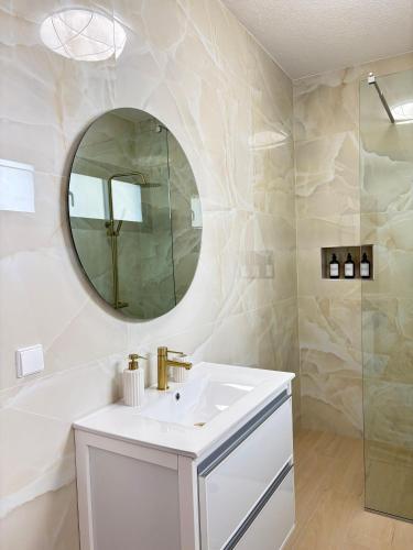 a white bathroom with a sink and a mirror at Casa estrelicia II in Relógio do Poiso