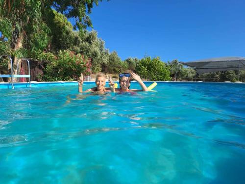 due persone in acqua in piscina di Charly Point Villa a Methoni