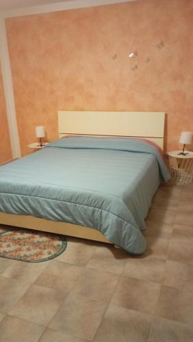 een bed in een kamer met twee lampen op tafels bij Casa Alice in Ciriè