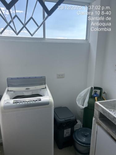 a small refrigerator in a kitchen with a toilet at Hermoso Apartasol en Santa Fe de Antioquia!!! in Santa Fe de Antioquia
