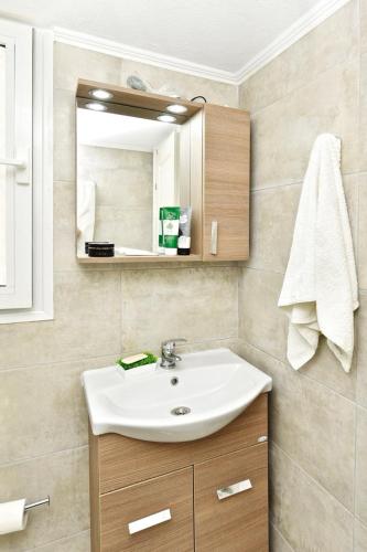 a bathroom with a sink and a mirror at Oikos in Hanioti