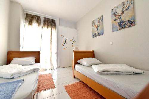 a bedroom with two beds and a window at Oikos in Hanioti