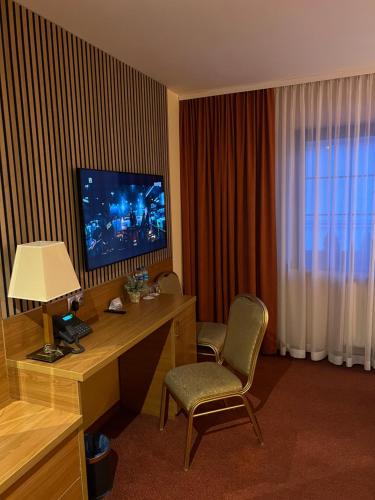 a hotel room with a desk with a television and a computer at Hotel Restauracja Willa Radwan in Aleksandrów Kujawski