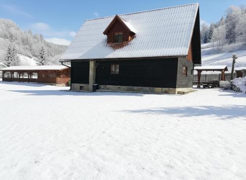 a black barn with snow on the ground at Chata Sipkova I in Terchová