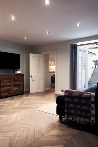 a living room with a television and a couch at Stylish-Luxury Seaside Flat on Georgian Square in Hastings