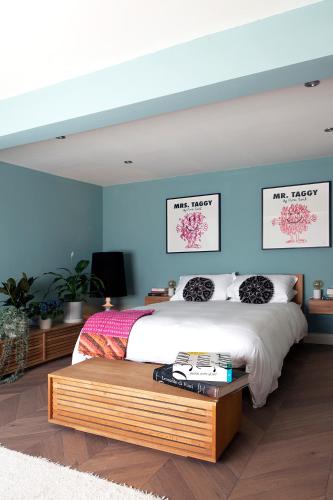 a bedroom with a large bed and blue walls at Stylish-Luxury Seaside Flat on Georgian Square in Hastings