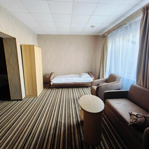 a living room with a couch and a bed at Hotel Riviera in Mierzyn