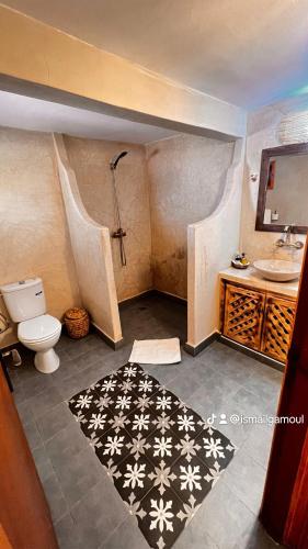 a bathroom with a shower and a toilet and a sink at Hotel Soleil Blue in Boumalne Dades