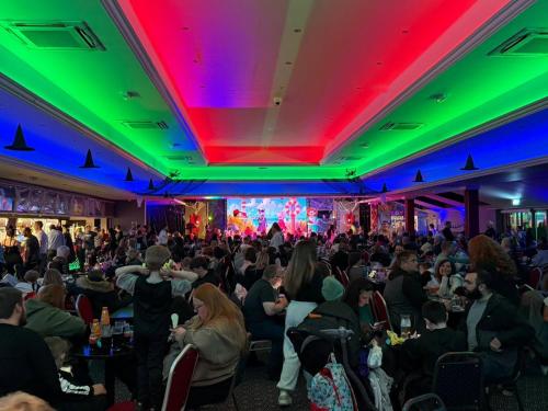 een menigte mensen die in een kamer met lasers zitten bij Lyon's Robin Hood Rhyl 8 Berth Caravan in Rhyl