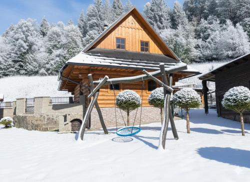 een speeltuin in de sneeuw voor een hut bij Chata Sipkova II in Terchová