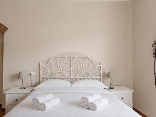 a bedroom with a white bed with three rolled towels at Paradise Apartment, Comfort e Private Parking in Prato