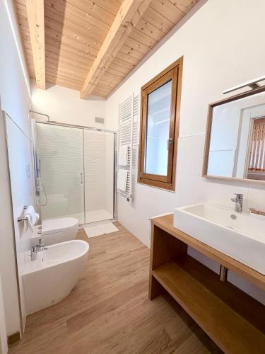 a bathroom with two sinks and a tub and a toilet at MARCO APARTMENTS di Locanda da Marco in Pignone