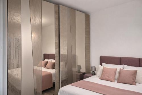 a bedroom with two beds and a mirrored wall at QUEEN HOME Luana in Venice