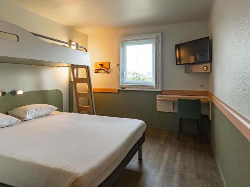 een slaapkamer met een stapelbed en een bureau bij ibis budget Marne la Vallée Pontault Combault in Pontault-Combault