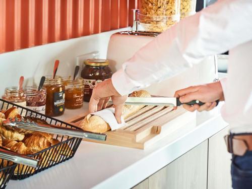 een bakker die brood bereidt op een plank in een keuken bij ibis budget Issoire in Issoire