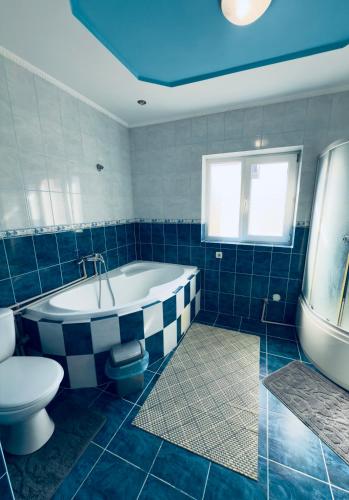 a bathroom with a tub and a toilet and a sink at Садиба у "Степана" in Synevyrsʼka Polyana