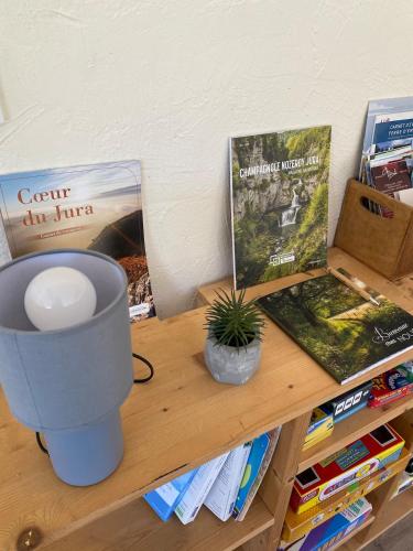 a table with a lamp and a book on it at La colonie in La Perrena