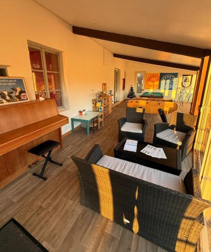 a living room with a piano and a couch at La colonie in La Perrena