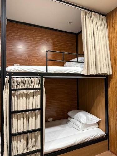 two bunk beds in a room with white pillows at Peanut Stay Hostel in Hanoi
