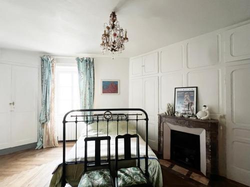 una camera da letto con camino e letto in ferro battuto di Très bel appartement en plein centre d'Arbois ad Arbois
