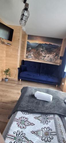 a living room with a blue couch and a rug at Przy Potocku in Czarna Góra