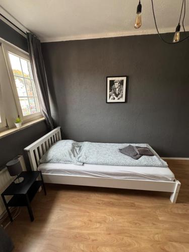 a bedroom with a bed with a gray wall at DoubleRoom in shared apartment 2nd floor in Linz am Rhein