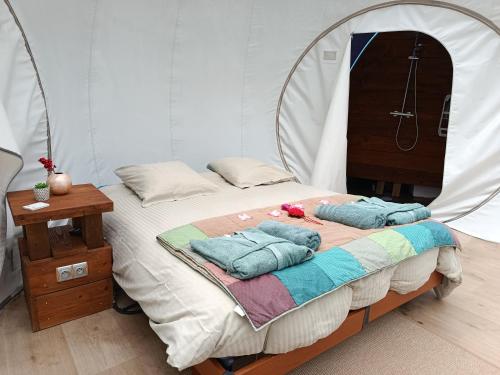 a bed in a tent with two pillows on it at Les Bulles du Coq de Champagne in Dormans