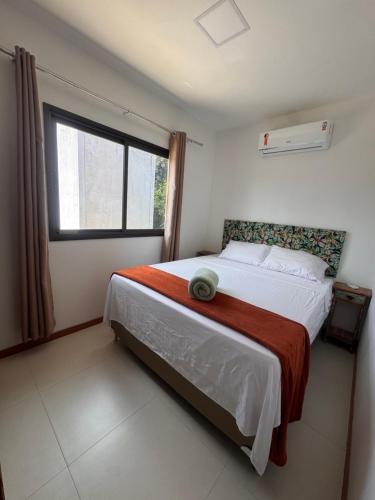 a bedroom with a large bed with a large window at Casa Tororão - Arraial d'Ajuda in Porto Seguro