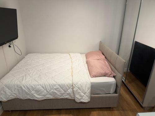 a small bedroom with a bed and a flat screen tv at Vivienne Apartment in Kavač