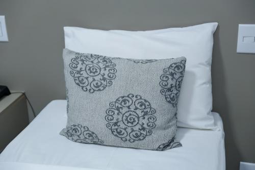 a gray pillow sitting on top of a bed at Verona Tower Hotel in Divinópolis